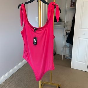 Bright pink boat neck body suit.